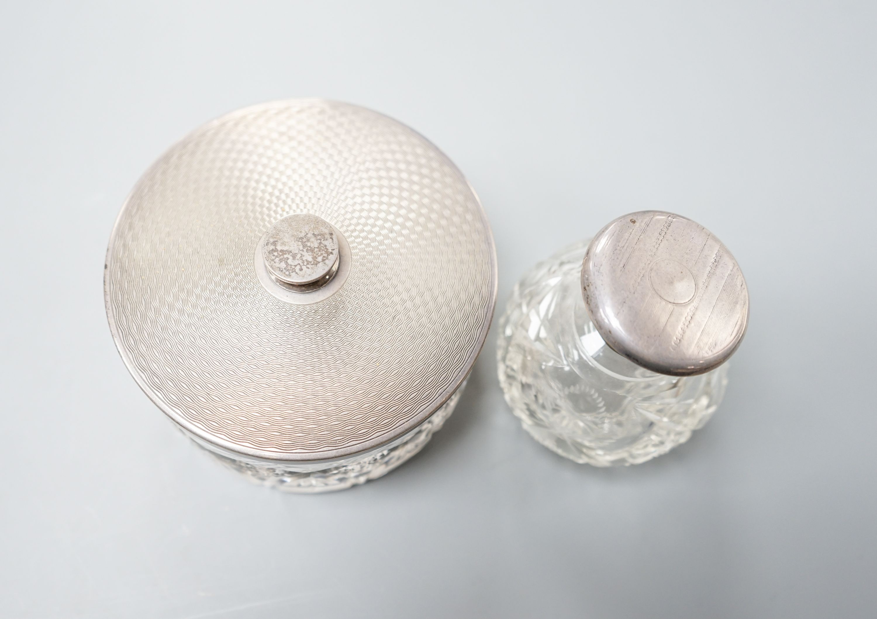 A silver-backed hand mirror and hairbrush, a silver-mounted scent bottle and a powder bowl.